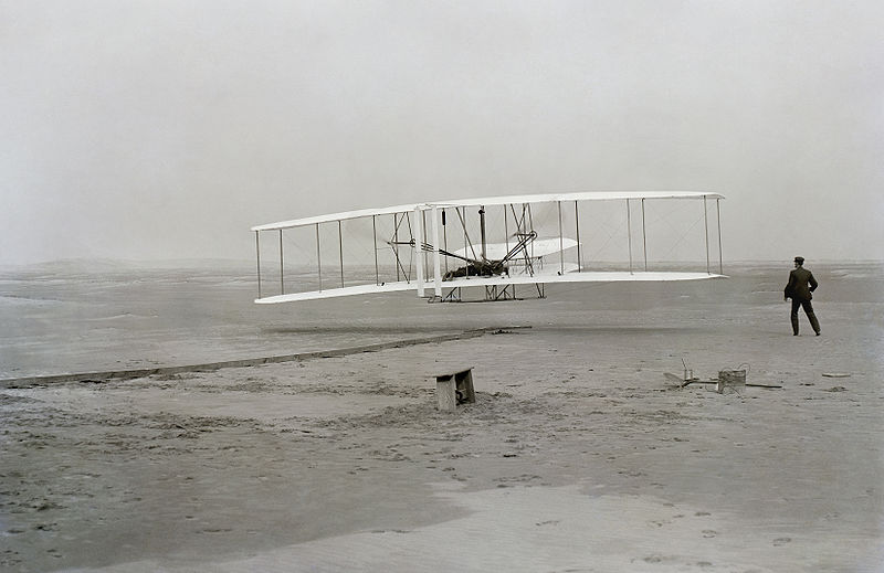 First successful flight of the Wright Flyer, by the Wright brothers. The machine traveled 120 ft (36.6 m) in 12 seconds at 10:35 a.m. at Kitty Hawk, North Carolina. Orville Wright was at the controls of the machine, lying prone on the lower wing with his hips in the cradle which operated the wing-warping mechanism. Wikipedia